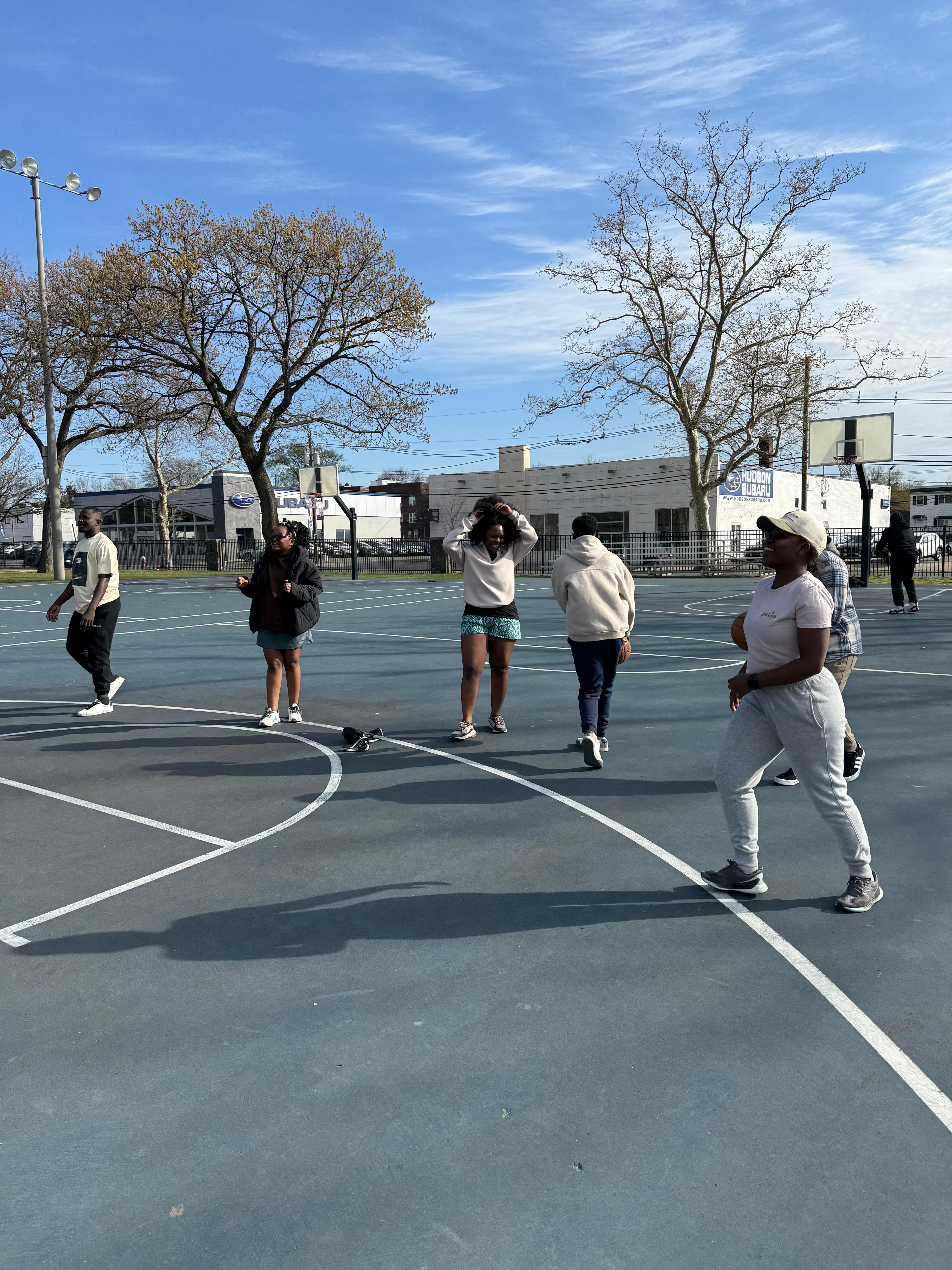 MAGIS members spending time together on a sunny outdoor basketball court