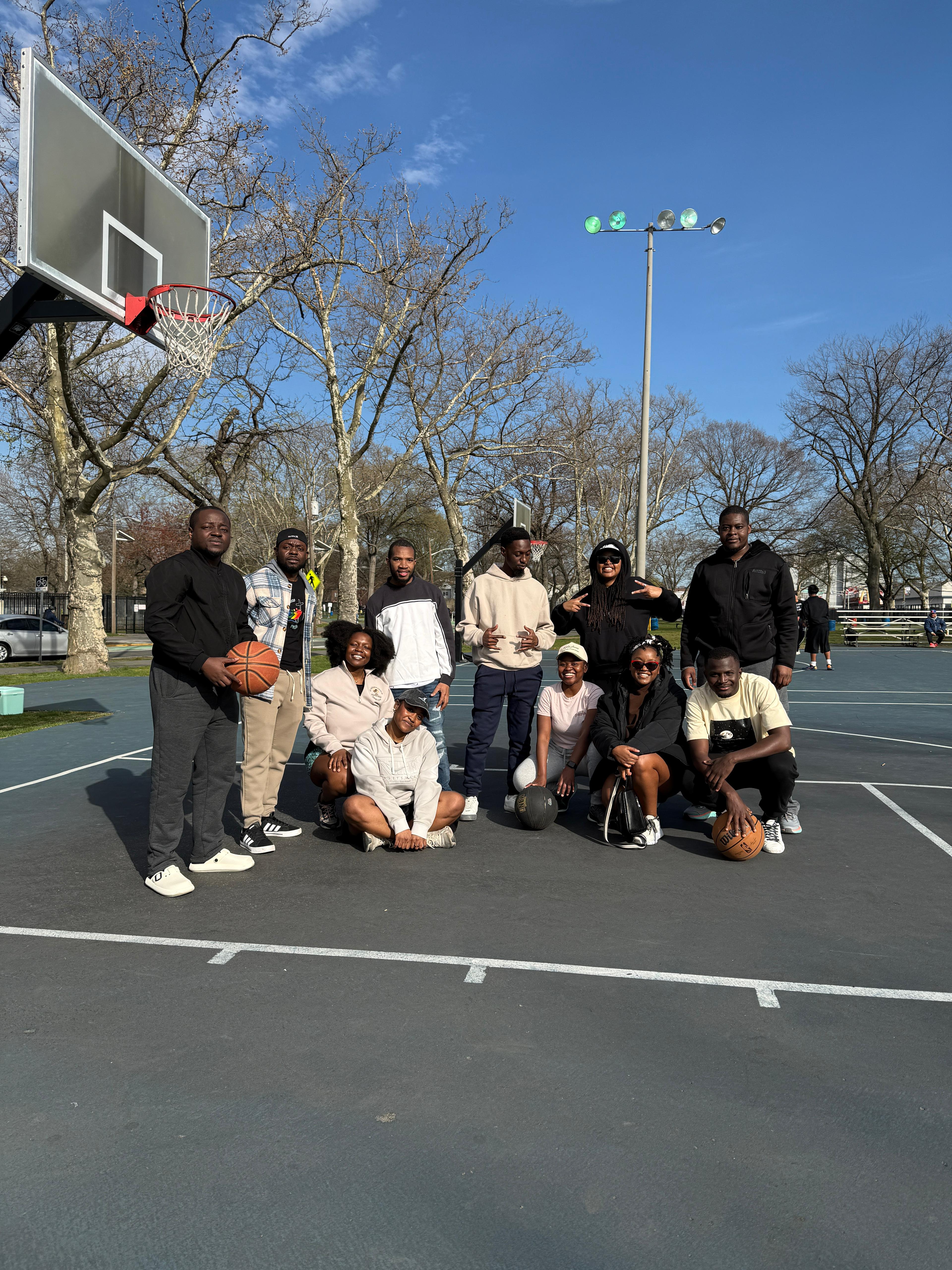 MAGIS USA community posing together on an outdoor basketball court